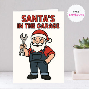 Santa’s in the Garage Christmas Card – Funny Mechanic Holiday Card for Car Guys, Gearheads & Auto Technicians